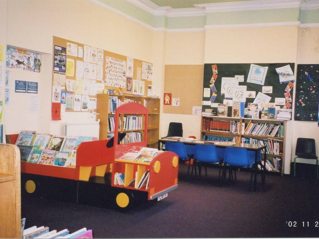 Wooden train filled with books in the children's area of a library